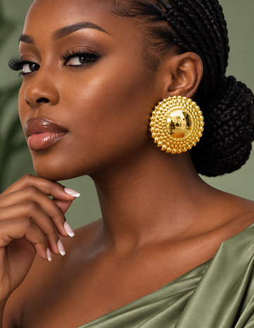 Woman wearing round gold Nubian Goddess jumbo stud earrings with beaded borders
