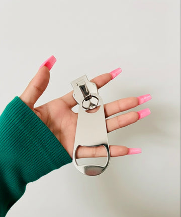 Oversized silver-tone ornamental pin displayed in hand