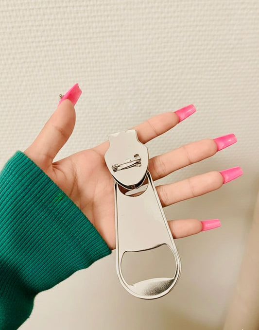 Back of oversized silver-tone ornamental pin displayed in hand
