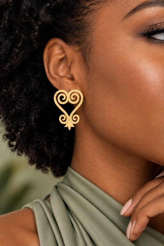 Close-up of a woman wearing a gold Sankofa swirl stud earring