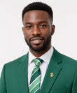 Man in green suit wearing gold Gye Nyame brooch