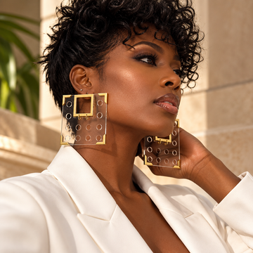 Woman wearing oversized clear square Geo earrings with gold-tone details