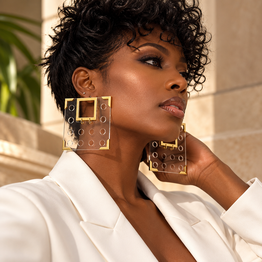 Woman wearing oversized clear square Geo earrings with gold-tone details