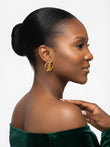 Side view of a woman wearing a small gold Gye Nyame stud earring