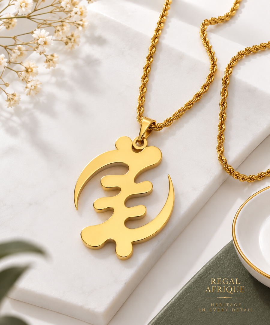 Close-up of a gold Gye Nyame XL pendant and rope-style chain on white stone