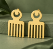 Pair of gold Duafe comb-shaped stud earrings on sage-green fabric