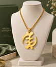 Gold Gye Nyame XL pendant necklace displayed on a cream-colored jewelry bust